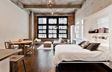 Lit escamotable king urbain blanc lustré dans un loft.